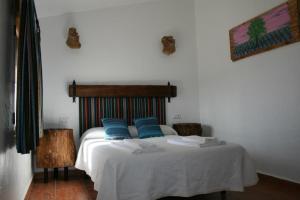 Un dormitorio con una cama con almohadas azules. en El Molino de Iramala, en Reolid