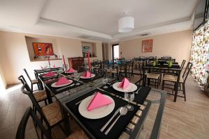 jadalnia ze stołami i krzesłami oraz różowymi serwetkami w obiekcie Villa Diana - Pesaro mare e cultura - intera struttura con piscina w mieście Mombaroccio