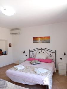 a bedroom with a large bed with pink pillows at Balcone delle mura in Cefalù