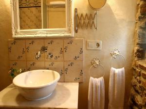 a bathroom with a sink and a mirror and towels at La Casa de Campo I in Lamuño