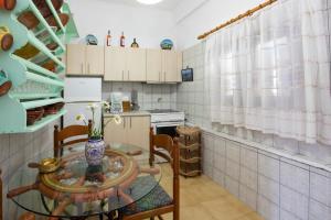 a small kitchen with a glass table and a table at Eutuxia Sea House in Vathi