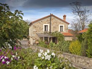 a stone house with a garden in front of it at La Casa de Campo I in Cudillero