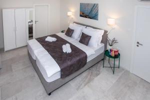 a bedroom with a large bed with two towels on it at Villa Fig in Split