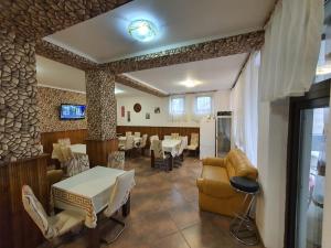 um restaurante com uma sala de jantar com mesas e cadeiras em Pensiunea Eden em Băile Olăneşti