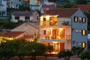 a house with a balcony in a city at Apartments Popaj in Komiža