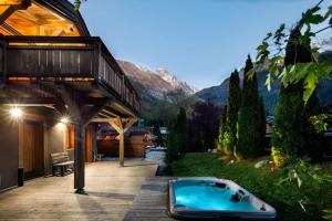 una bañera de hidromasaje en una terraza junto a una casa en Les Rives d'Argentière, en Chamonix-Mont-Blanc
