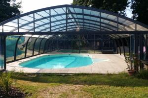 a glass greenhouse with a swimming pool at Grande maison avec piscine couverte et chauffée in Saint-Barthélemy