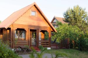 a wooden cabin with a porch in a yard at Domek całoroczny nad morzem Stegna Baltica in Stegna