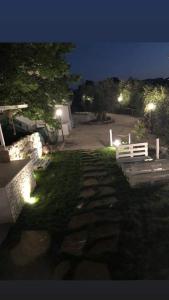 um parque com bancos e luzes na relva à noite em Pozzo dei Desideri Appartamenti em Peschici