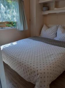 uma cama num pequeno quarto com uma janela em Domki holenderskie ,, Latający Holender" em Dębki