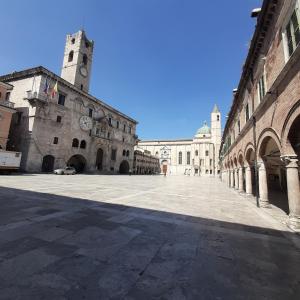 una strada vuota con un edificio con una torre dell'orologio di La Chicca in centro - Centro storico Ascoli Piceno ad Ascoli Piceno