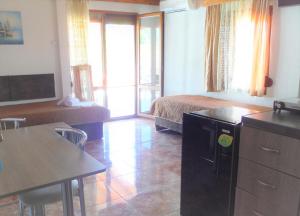 a hotel room with a bed and a table and a kitchen at Edelweiss Studios in Limenas