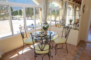 a dining room with a table and chairs and windows at Villa Mariana in Almería