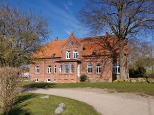 a large brick building with a red roof at Gutshaus Thorstorf FeWo Wismar in Thorstorf