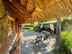 eine Terrasse mit zwei Stühlen und einer Bank auf einem Haus in der Unterkunft Pirtiņa in Ogre