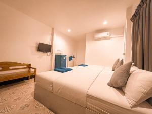 a hotel room with a bed and a television at KohLan Hansa in Ko Larn
