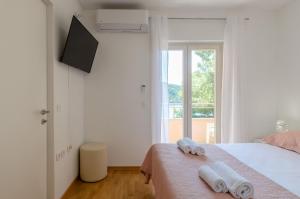 a bedroom with a bed with two towels on it at Pine Tree Apartment Zanetic in Blato