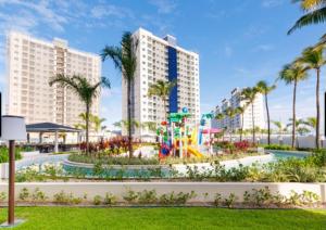 um parque infantil num resort com palmeiras e edifícios em Salinas Exclusive Resort em Salinópolis