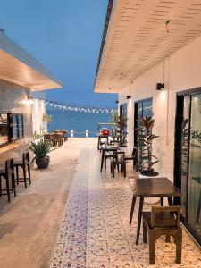 un patio con tavoli, sedie e vista sull'oceano di KohLan Hansa a Ko Larn