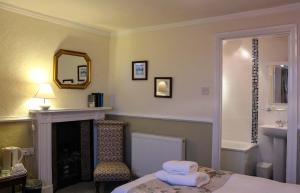 a room with a bed and a fireplace and a mirror at Kersbrook Guest Accommodation in Lyme Regis