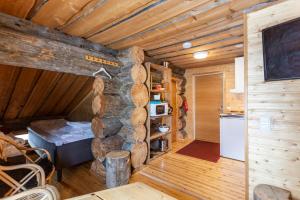 a room with a stone wall in a log cabin at Kuukkeli Apartments Pikku-Hirvas ja Porotokka in Saariselka