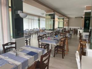 a restaurant with tables and chairs with blue tables at Hotel Villa Etrusca in Marina di Campo