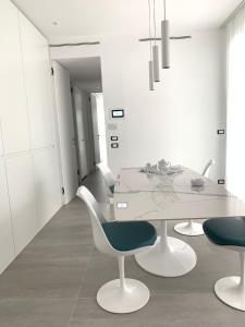 Cette chambre blanche dispose d'une table et de chaises blanches. dans l'établissement PLAYA DORADA, à Lido di Jesolo