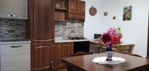 una cucina con tavolo e vaso di fiori di B&B Le Cerque a Crocicchia