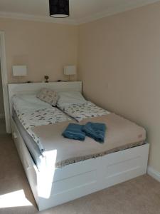 a white bed with two blue towels on it at Poseidon Friends in Bournemouth