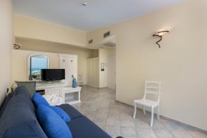 ein Wohnzimmer mit einem blauen Sofa und einem Sessel in der Unterkunft Hotel Riviera in San Vito lo Capo