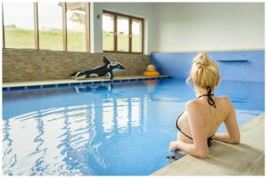 una chica sentada en una tabla de surf en una piscina en Kaniówka Ski Resort, en Białka Tatrzanska