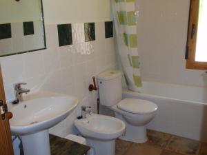 Un baño con lavabo, inodoro y bañera. en El Molino de Iramala, en Reolid