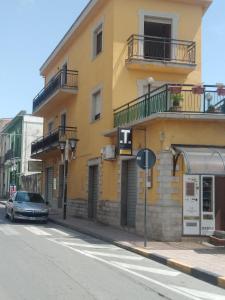 a yellow building with a car parked in front of it at Appartamento Risoli GP in Scalea