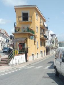 a yellow building on the side of a street at Appartamento Risoli GP in Scalea