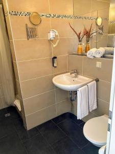 a bathroom with a sink and a toilet at Hotel am Park in Willich