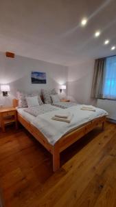 a large bed in a room with wooden floors at Kalvarienberg Appartement Gosau in Gosau