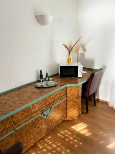 a kitchen counter with a microwave and a sink at Hotel am Park in Willich