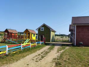 a group of houses in a field next to a dirt road at Domki u Iwonki -brązowy in Niechorze