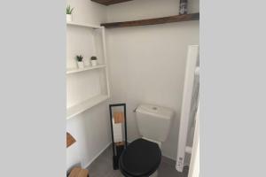 a bathroom with a toilet with a black seat at Studio Collobrières Vue sur village in Collobrières