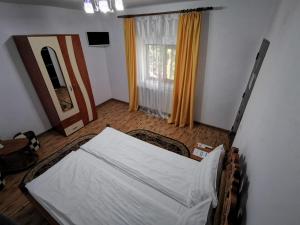 Un pat sau paturi într-o cameră la Pensiunea Eden