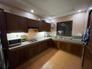 a kitchen with wooden cabinets and a microwave at Superbe villa marrakech in Marrakesh