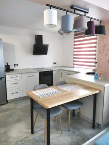 een keuken met een houten tafel en 2 stoelen bij Apartment no 11 - Amarilia Apartments in Constanţa