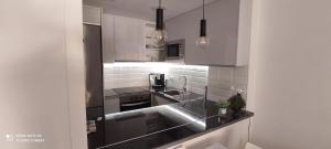 een keuken met witte kasten en een wastafel bij RELAX i SOL in Cambrils