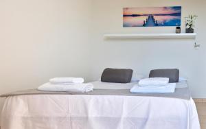 una camera bianca con un letto e asciugamani di Sibylla Apartment a Sperlonga