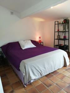 una camera da letto con un letto grande con lenzuola viola di La Bastide avec Piscine, au cœur de la Provence a Sainte-Anastasie-sur-Issole
