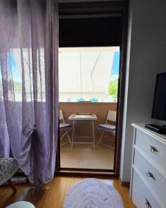 a room with a sliding glass door with a table and a window at Perla Apartment Postira Island of Brač in Postira