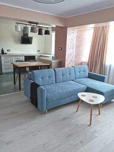 een woonkamer met een blauwe bank en een tafel bij Apartment no 11 - Amarilia Apartments in Constanţa