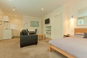 - une chambre avec un lit, une chaise et un bureau dans l'établissement Sixty Two On Grey Serviced Apartments, à Melbourne