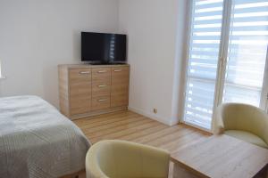 Dormitorio con cama y tocador con TV en Apartament Assolato en Władysławowo