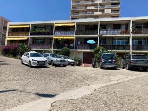 un estacionamiento con autos estacionados frente a un edificio en Rosie's Club en Ajaccio